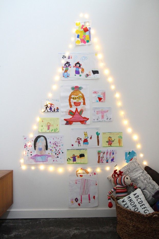 Le sapin des enfants : un triangle en guirlande au mur, rempli de dessins ! Crédit photo : Pinterest/madecocommelesgrands.com Sapin Noël avec guirlande LED et dessins d'enfants